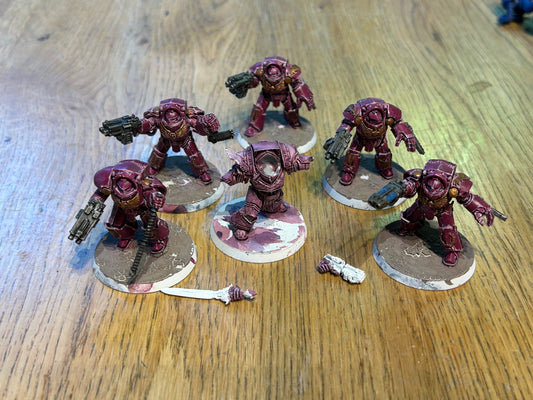 Emperor’s children Horus Heresy terminators (I believe they’re the earlier forge world ones). Missing one head and the banner pole